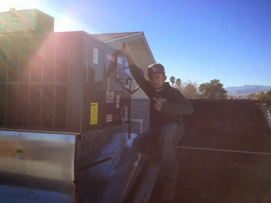 HVAC technician performing AC Tune-Up on a rooftop unit in Virginia